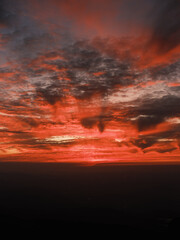 Dramatic Red Sunset Over Mountain Horizon with Vibrant Clouds