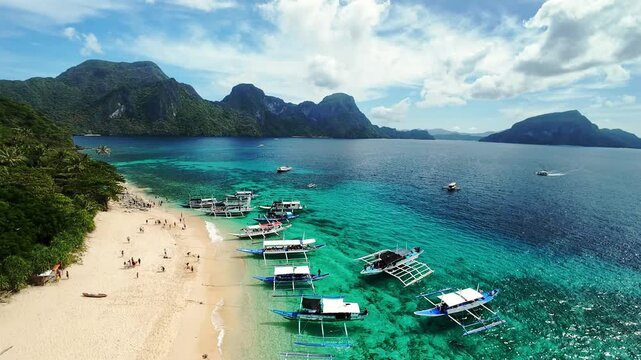 El Nido beachscape with turquoise water, boats, and limestone mountains in Palawan, Philippines Tropical paradise beach with boats and mountains in El Nido, Palawan, Philippines