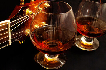 Glass of cognac and on the classic guitar