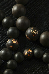 A wooden bead bracelet laid flat, showcasing natural materials and craftsmanship,is the raw material display, black wooden beads