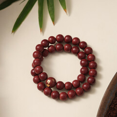 A wooden bead bracelet laid flat, showcasing natural materials and craftsmanship,is an accessory that can be worn on the wrist or ankle