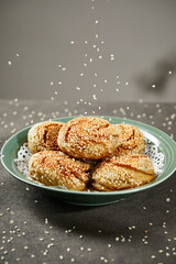 Close up shot of sesame cakes placed on a plate, on a stone table indoors
