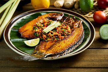 Fried fish and chili seasoning spread on leaves, Southeast Asian cuisine