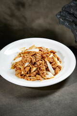 White onion and lamb or beef rolls served on a white plate
