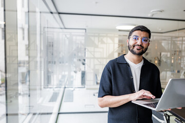 Professional man working on laptop in a modern office environment, showcasing productivity and focus