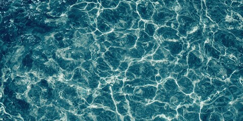 Obraz premium The mesmerizing patterns of light and reflection dance across the water's surface in tranquil blue tones.