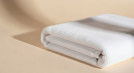 Soft White Bath Towel Folded Neatly on Beige Background, Minimalist Home Spa Concept, Luxurious Texture, Clean and Fresh