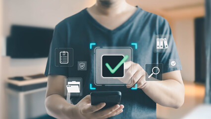 A man uses a smartphone to interact with a virtual interface, touching a large green checkmark icon for approval among various digital document management system icons.