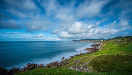 Fototapeta premium a serene coastal landscape with lush green hills and expansive blue sky