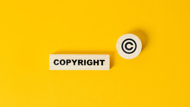 The word copyright and copyright symbol on wooden blocks. Concept of patenting. or copyright protection.