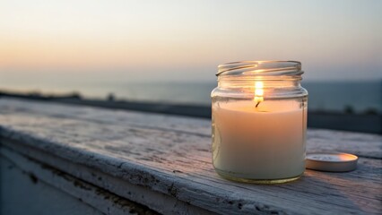 Candle glowing on weathered surface at sunset over sea