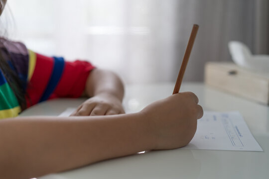 mathematics by closeup hand child writing calculate numbers or person kid girl student doing homework in paper by pencil to studying in classroom or learn from home and learning quick math calculation