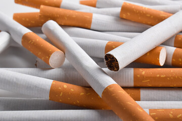 Pile of cigarettes with filters isolated on white background, close up
