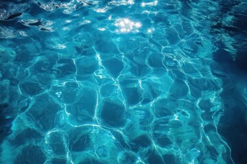 Obraz premium Close-up view of clear blue water surface with sunlight reflections creating shimmering patterns