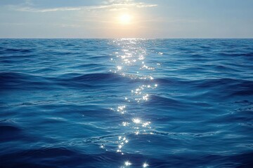 Fototapeta premium Shimmering sunlight reflecting off calm blue ocean waves during clear sky sunset