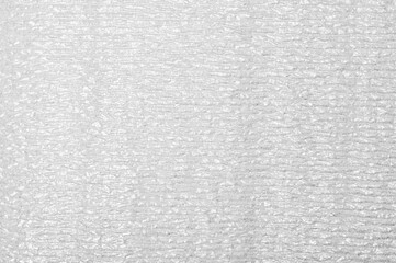 A grey and white fabric with a pattern of lines. The fabric is very thin and has a rough texture