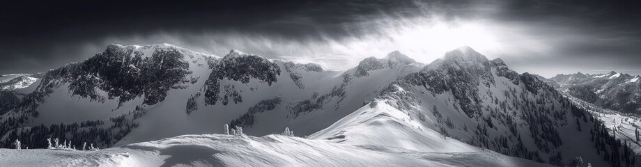 Obraz premium Panoramic black and white view of snow-covered mountain range under dramatic cloudy sky evoking calm and majesty