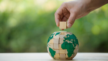 Hand completing Earth globe puzzle, symbolizing global collaboration now