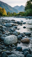 A shallow rocky river flowing through a lush valley, with mountains blurred in the background, captured during twilight