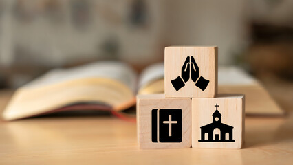 Faith symbols depicted on wooden blocks with an open book in background