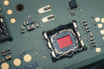 Close-up view of a smartphone camera sensor without lens, mounted on a green electronic circuit board with visible components.