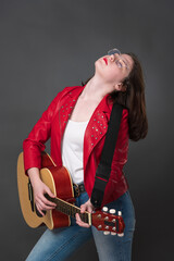Female guitarist adopts posture with head thrown back, and she performs soulful rendition on guitar. Woman's exuberant performance of guitar, passion, contributes to performance's overall dynamism