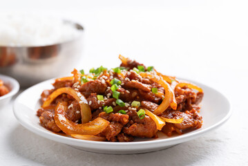 Korean stir fried spicy pork (Bulgogi) on plate with cooked rice and kimchi