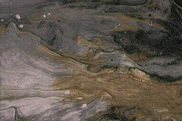 Elegant abstract background of flowing metallic gold, grey, and black liquid paint creating a dynamic marbled texture