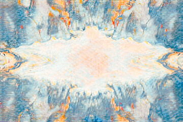 Abstract symmetrical marbled texture background with blue and orange paint splashes and a central copy space