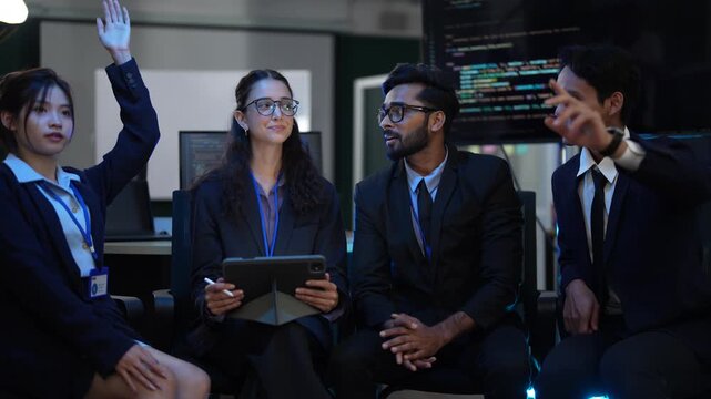 A cybersecurity team in a Security Operations Center SOC analyzes a threat intelligence report on a tablet, coordinating an incident response plan during a late night shift.