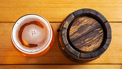 Frothy golden ale beside dark wooden barrel beer foam