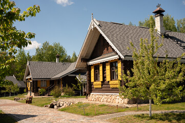 Rustic wooden cottages in sunny countryside setting surrounded by lush greenery