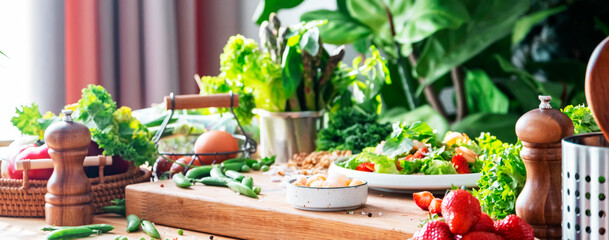 Gourmet salad with lettuce, strawberry, shrimps and walnuts on table in bright modern kitchen