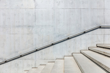 outdoor stairs with handrails on gray concrete wall. view on sunny bright day.