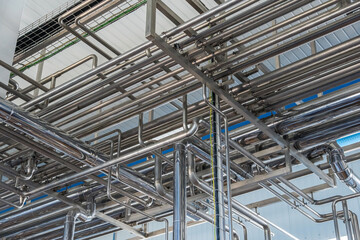 Stainless steel pipes under ceiling in industrial facility