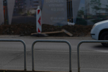 A glimpse of a busy urban construction site featuring a white vehicle and a safety barrier, reflecting urban development trends.