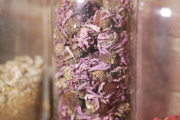 Dried purple flowers in glass container at herbal shop