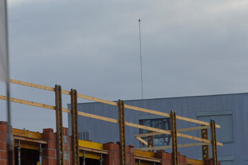 A construction site showcasing wooden framework under a cloudy sky, representing urban development and construction progress.