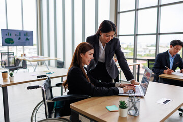 Confident asian woman in wheelchair collaborates with her business team in office setting, representing workplace equality, leadership diversity, and inclusive teamwork for professional growth