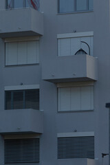 Exterior view of a contemporary apartment building showcasing multiple balconies and window features.