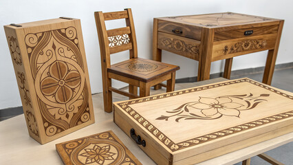 A handcrafted wooden furniture with intricate carved floral designs on a light surface in deco art