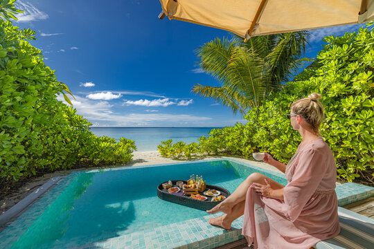 Sexy elegant woman relaxing poolside with cocktails on lounge chairs under umbrella, paradise island beach view, tropical resort luxury, floating breakfast on calm pool water for summer vacations