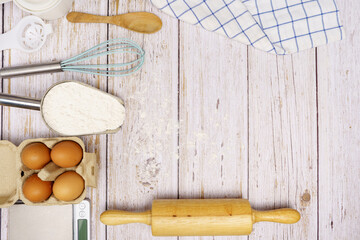 Homemade Dough Recipe (Eggs, flour, milk, sugar) and wooden kneading dough on a wooden table, view from above	
