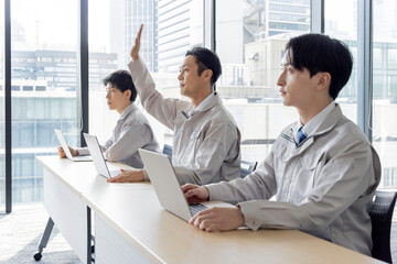 研修を受ける作業着を着たビジネスパーソン