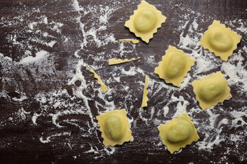 Flat lay composition with raw ravioli on wooden table. Italian pasta