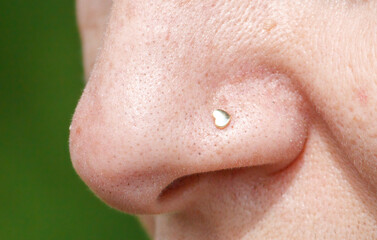 A nose with a heart shaped nose stud