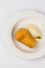 top view of a rum babka dessert with cream and sorbet in close-up on a white background