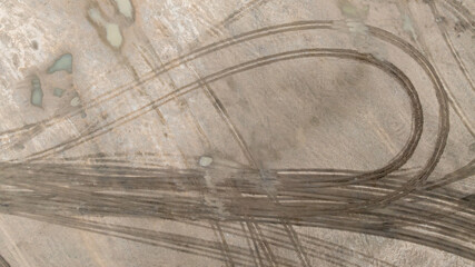 Aerial top view tire track on dirt sand mud, Texture of wet mud road with puddle and Tyre or tire track in countryside, Wheel tyre or tire track on mud, texture and background.