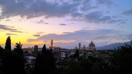 Naklejka premium Florence, Italy at night with illuminated cathedral, Arno River reflections, and historic city skyline.