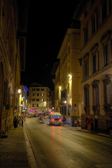 Naklejka premium Florence, Italy at night with illuminated cathedral, Arno River reflections, and historic city skyline.